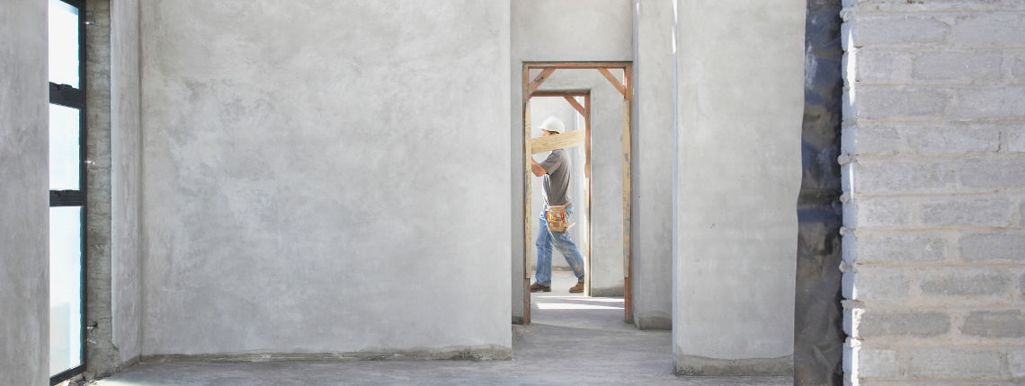 worker carrying wood in new structure